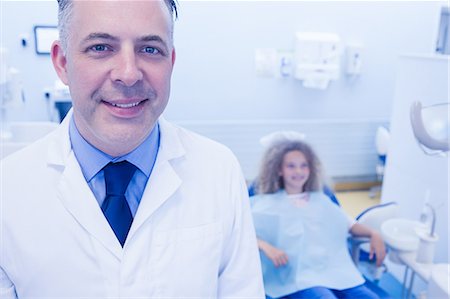 dentist bib girl - Pediatric dentist and little girl smiling at the camera Stock Photo - Premium Royalty-Free, Code: 6109-08389702
