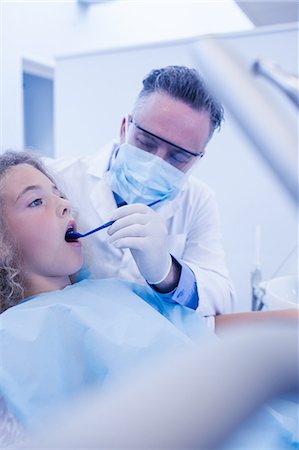 dentist bib girl - Pediatric dentist examining his young patient Stock Photo - Premium Royalty-Free, Code: 6109-08389704