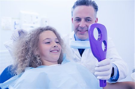 simsearch:6109-08389794,k - Pediatric dentist showing patient new smile Stockbilder - Premium RF Lizenzfrei, Bildnummer: 6109-08389705