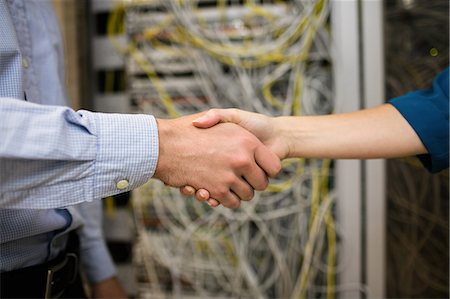 simsearch:6109-08389895,k - Technicians shaking hands in server room Stock Photo - Premium Royalty-Free, Code: 6109-08389897