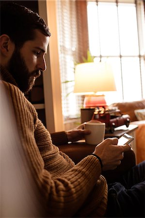 Handsome hipster using his phone Stock Photo - Premium Royalty-Free, Code: 6109-08390053