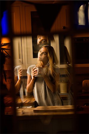 simsearch:6109-08390353,k - Pretty woman drinking coffee in the kitchen Stock Photo - Premium Royalty-Free, Code: 6109-08390070