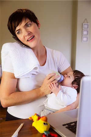 simsearch:400-08932328,k - Mother feeding her baby and having phone call Stock Photo - Premium Royalty-Free, Code: 6109-08390039