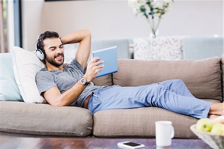 relax home tablet - Handsome man using tablet and headphones Stock Photo - Premium Royalty-Free, Code: 6109-08390104