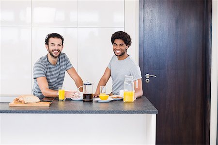 Happy gay couple having breakfast and looking at camera Photographie de stock - Premium Libres de Droits, Code: 6109-08390260