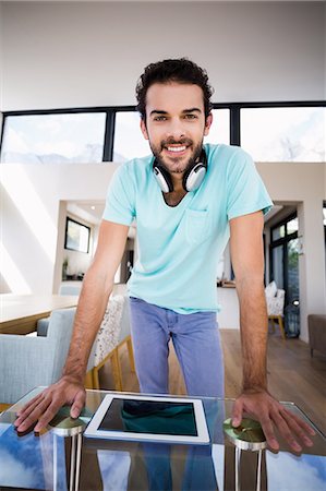 simsearch:6109-08390544,k - Handsome man with headphones leaning with hands on table Stock Photo - Premium Royalty-Free, Code: 6109-08390380