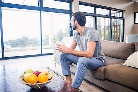 simsearch:6109-08390353,k - Handsome man holding white cup looking out the window Stock Photo - Premium Royalty-Free, Code: 6109-08390392