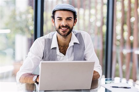 professional (pertains to traditional blue collar careers) - Smiling man using laptop Stock Photo - Premium Royalty-Free, Code: 6109-08390321