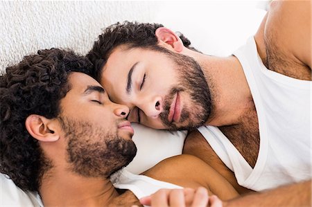 Happy gay couple sleeping together on bed Foto de stock - Sin royalties Premium, Código: 6109-08390407