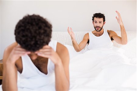 Homosexual couple having argument on bed Foto de stock - Sin royalties Premium, Código: 6109-08390418