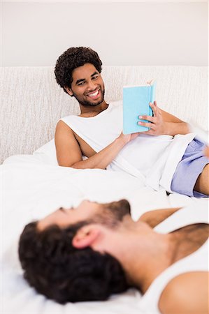 Smiling man holding book talking with his partner Stock Photo - Premium Royalty-Free, Code: 6109-08390422