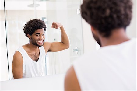 simsearch:6109-08435552,k - Smiling man looking at his biceps in mirror Stockbilder - Premium RF Lizenzfrei, Bildnummer: 6109-08390429