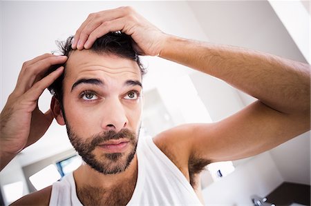 simsearch:6109-08435552,k - Concentrated man looking at his hair Stockbilder - Premium RF Lizenzfrei, Bildnummer: 6109-08390436
