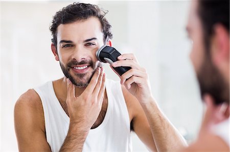 simsearch:6109-08435552,k - Reflection of smiling man shaving with electric razor Fotografie stock - Premium Royalty-Free, Codice: 6109-08390439