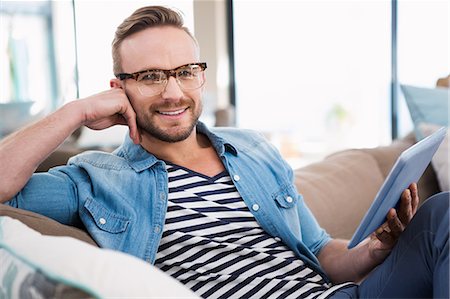 simsearch:6109-08390544,k - Casual man using tablet on sofa Stock Photo - Premium Royalty-Free, Code: 6109-08390544