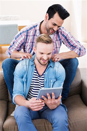 simsearch:6109-08390086,k - Gay couple relaxing on the couch using tablet Foto de stock - Sin royalties Premium, Código: 6109-08390561