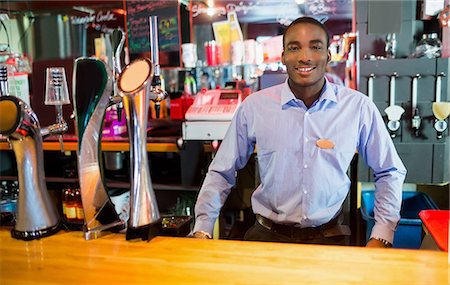 simsearch:6109-08394900,k - Smiling barkeeper posing near tap Foto de stock - Royalty Free Premium, Número: 6109-08394866