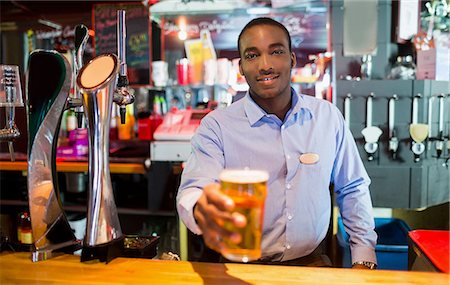 simsearch:6109-08394900,k - Barkeeper serving glass of beer Foto de stock - Royalty Free Premium, Número: 6109-08394868