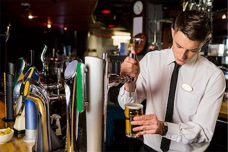 simsearch:6109-08394900,k - Well dressed bartender serving beer Foto de stock - Royalty Free Premium, Número: 6109-08394902