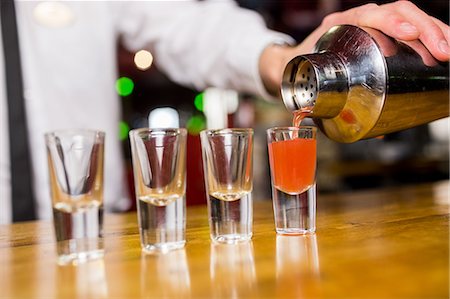 simsearch:400-03921226,k - Bartender pouring cocktail into glasses Stock Photo - Premium Royalty-Free, Code: 6109-08394909