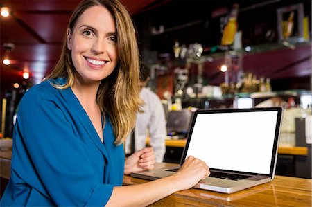 simsearch:6109-08394929,k - Smiling woman having a drink using laptop Stockbilder - Premium RF Lizenzfrei, Bildnummer: 6109-08394922