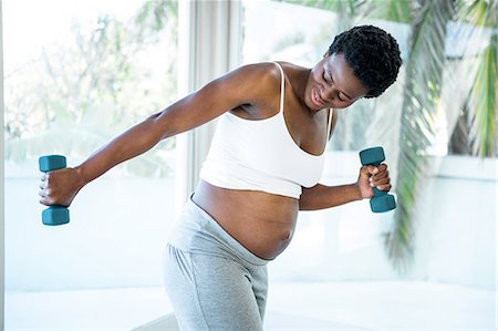 Pregnant woman exercising with dumbbells Stock Photos - Page 1 : Masterfile