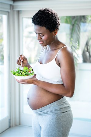pregnant black woman belly - Pregnant woman holding bowl of salad Stock Photo - Premium Royalty-Free, Code: 6109-08395178