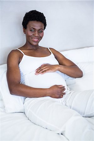 pregnant rubbing - Pregnant woman lying in bed Stock Photo - Premium Royalty-Free, Code: 6109-08395289