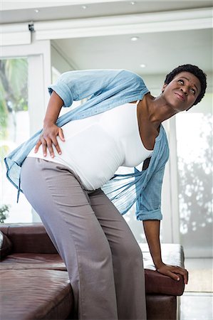 simsearch:632-08227406,k - Pregnant woman struggling to get up from the couch Foto de stock - Sin royalties Premium, Código: 6109-08395220