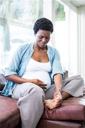 pregnant rubbing - Woman massaging her tired feet Stock Photo - Premium Royalty-Free, Code: 6109-08395231