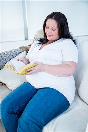 simsearch:6109-06194272,k - Cute pregnant woman reading a book on the couch Stock Photo - Premium Royalty-Free, Code: 6109-08395459