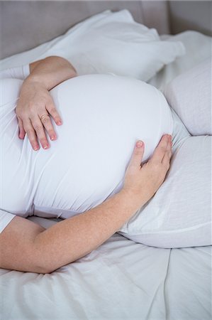 simsearch:6109-08489144,k - Lovely pregnant woman touching her belly Stock Photo - Premium Royalty-Free, Code: 6109-08395497