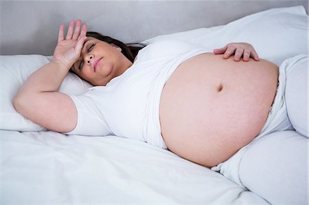 simsearch:6109-07497307,k - Sleeping pregnant lying on a bed Stockbilder - Premium RF Lizenzfrei, Bildnummer: 6109-08395498