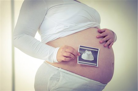 simsearch:6109-08395398,k - Pregnant woman holding sonogram near her belly Photographie de stock - Premium Libres de Droits, Code: 6109-08395417