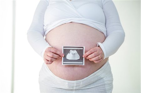 simsearch:6109-08395398,k - Pregnant woman holding sonogram near her belly Photographie de stock - Premium Libres de Droits, Code: 6109-08395416