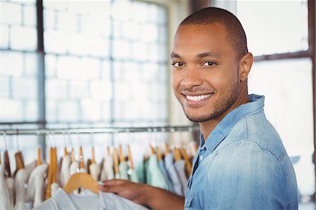 shopaholic (male) - Portrait of smiling man holding shirt at mall Stock Photo - Premium Royalty-Free, Code: 6109-08395644