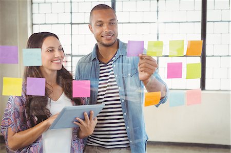 simsearch:6109-08390344,k - Woman holding tablet and looking at sticky note Foto de stock - Royalty Free Premium, Número: 6109-08395666