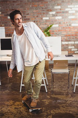 editor (male) - Man standing on skate board at office Stock Photo - Premium Royalty-Free, Code: 6109-08395685