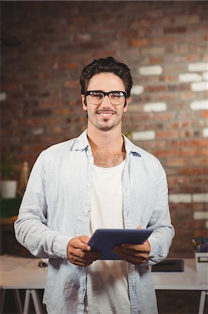 designer (graphic, male) - Smiling businessman using tablet at office Stock Photo - Premium Royalty-Free, Code: 6109-08395688