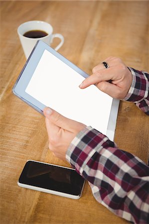 professing - Cropped image of man using tablet by smartphone Stock Photo - Premium Royalty-Free, Code: 6109-08395763