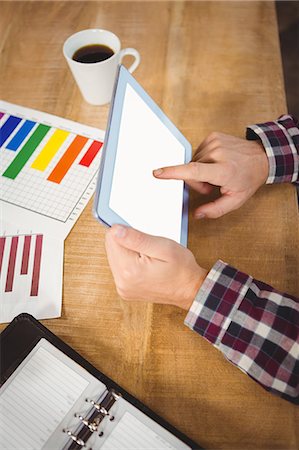 Cropped image of man using tablet by charts Photographie de stock - Premium Libres de Droits, Code: 6109-08395764