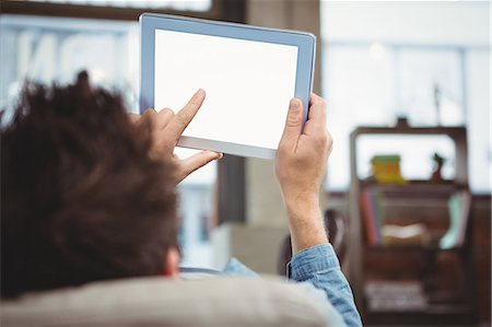 person working on computer at home - Close-up of man relaxing while using digital tablet Photographie de stock - Premium Libres de Droits, Code: 6109-08395781