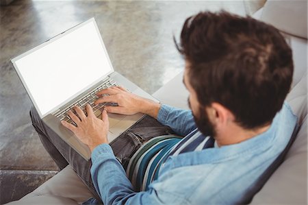 sofa in empty living room - Man working on laptop Stock Photo - Premium Royalty-Free, Code: 6109-08395788