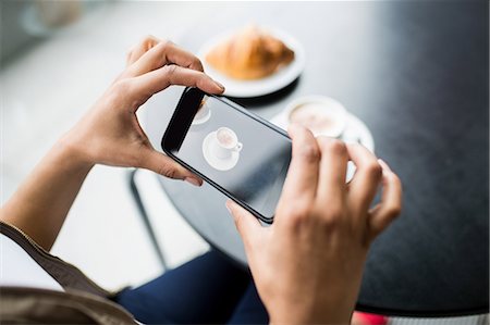 Pretty student using her phone in cafe Foto de stock - Sin royalties Premium, Código: 6109-08395879