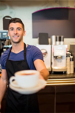 Handsome waiter smiling at camera Foto de stock - Sin royalties Premium, Código: 6109-08395980