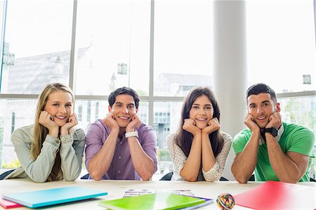 simsearch:6109-08396050,k - Students smiling at camera sitting in a line Foto de stock - Sin royalties Premium, Código: 6109-08396080