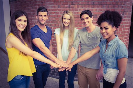 Students putting hands together in unity Stock Photo - Premium Royalty-Free, Code: 6109-08396014