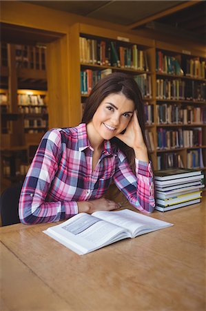 simsearch:6109-07497515,k - Female student smiling with book on table Photographie de stock - Premium Libres de Droits, Code: 6109-08396250