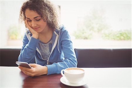 simsearch:400-08056574,k - Pretty student using her phone in cafe Stock Photo - Premium Royalty-Free, Code: 6109-08396462