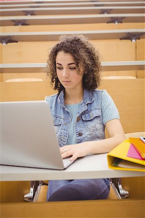 simsearch:6109-08396038,k - Pretty student in lecture hall using laptop Photographie de stock - Premium Libres de Droits, Code: 6109-08396427